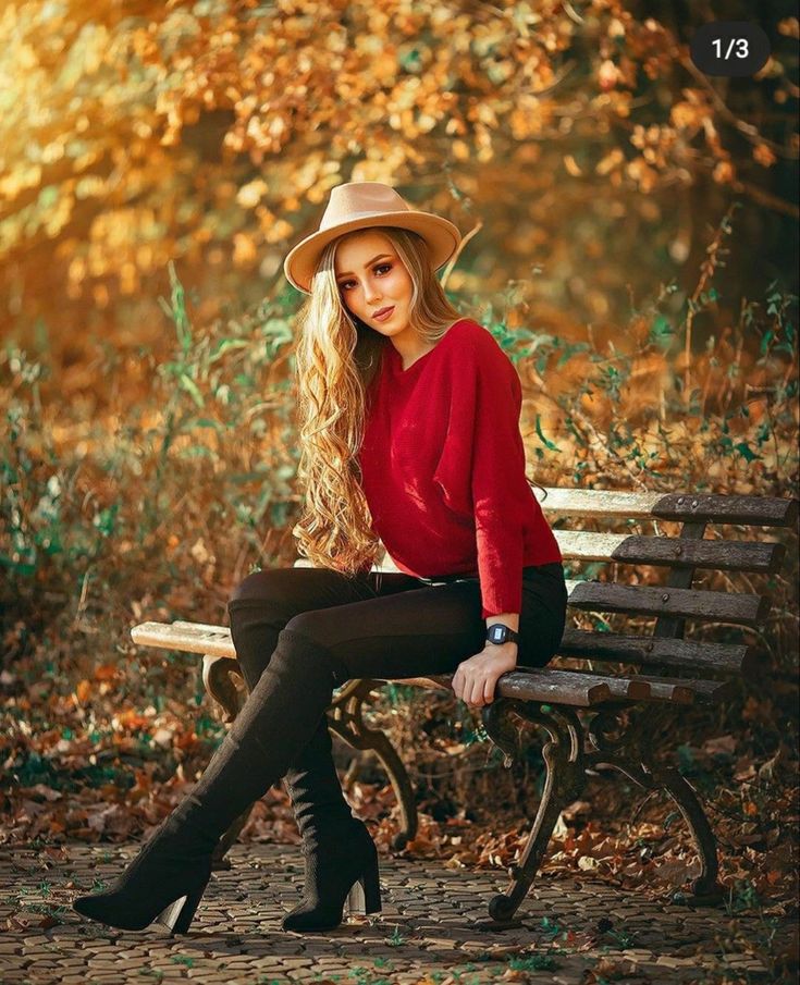 a woman sitting on top of a wooden bench