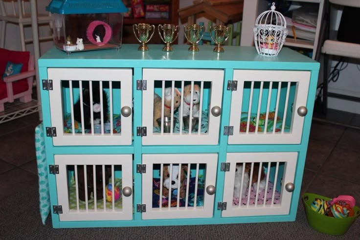 a blue and white toy cabinet with pictures on the front, two wine glasses sitting on top