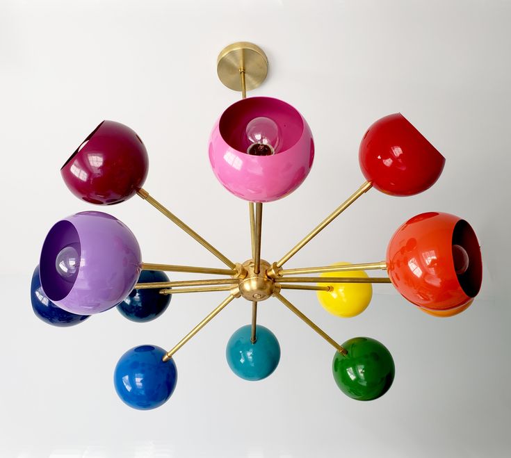 a multicolored chandelier hanging from the ceiling with eight lights in it