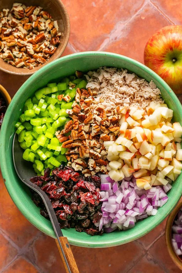 a bowl filled with apples, raisins, cranberries and nuts