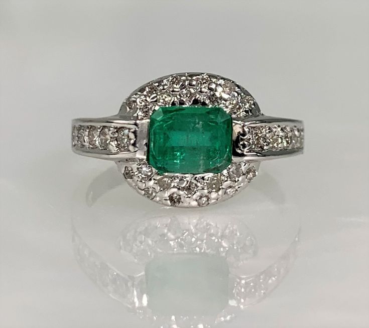 Emerald Ring Vintage, Emerald Diamond Ring, Emerald East West Ring, Emerald Engagement Ring, Emerald Cut Emerald Ring, Emerald Jewelry 14k A timeless yet trendy natural emerald ring featuring an emerald cut center stone weighing 0.86 carats uniquely set in an east/ west direction while accented by 1.26 carats of sparkling white diamonds set in solid 14k white gold.  *Ring size: US 6 3/4  *Ring weight: 4.68 Grams *Center stone dimensions: 6X5mm Fine Jewelry Emerald Ring In White Gold With Halo, Fine Jewelry White Gold Emerald Ring With Halo, White Gold Emerald Halo Ring Fine Jewelry, Emerald Rings In White Gold With Halo, Fine Jewelry Emerald Ring With Halo Design, Fine Jewelry Emerald Ring With Halo, Fine Jewelry Emerald Ring With Halo Setting, Gia Certified Green Diamond Ring In 14k White Gold, Platinum Rings With May Birthstone For Fine Jewelry