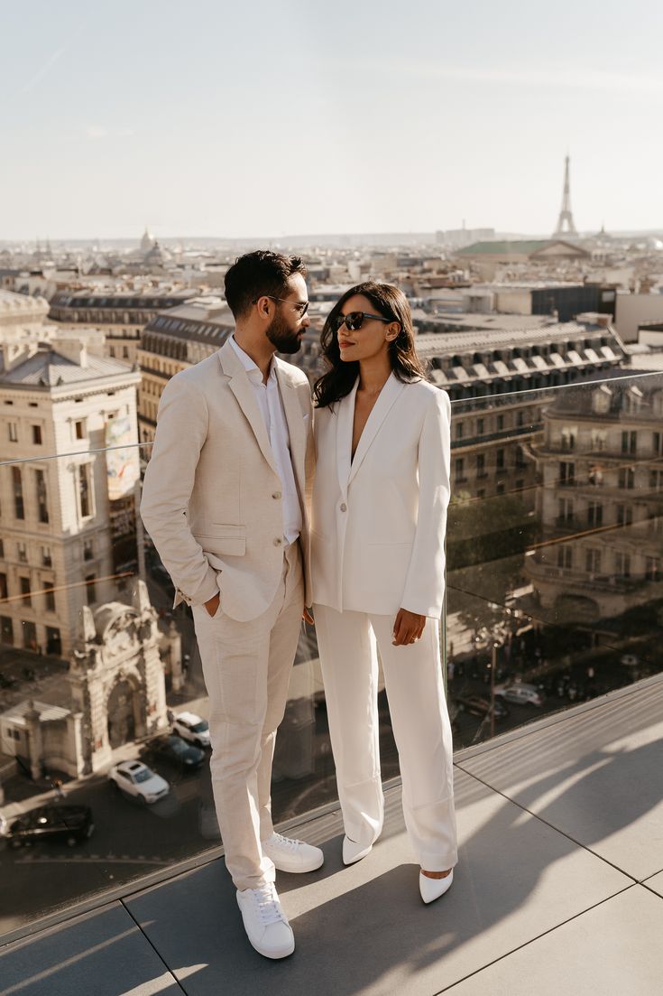 a man and woman standing on top of a building