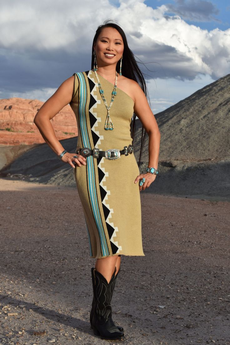 a woman standing in the desert with her hands on her hips and wearing cowboy boots