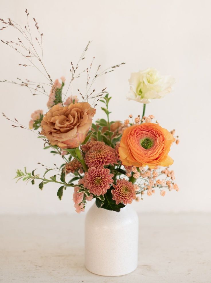 an arrangement of flowers in a white vase