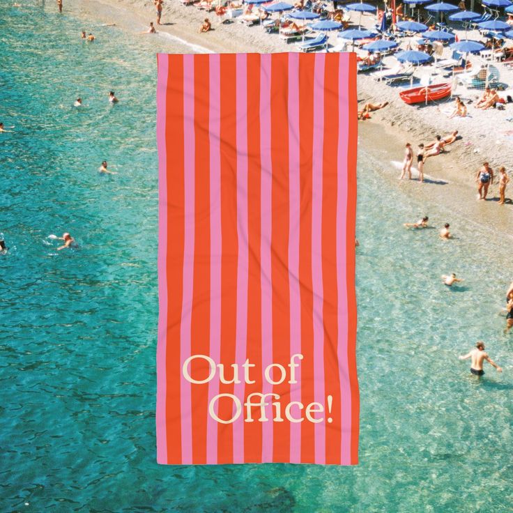 an orange and white beach towel with the words out of office written on it in front of a crowded beach