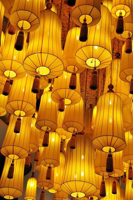 many yellow lanterns are hanging from the ceiling