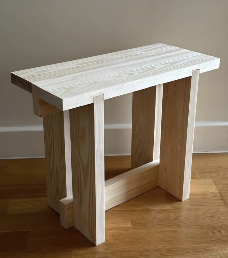 a wooden bench sitting on top of a hard wood floor