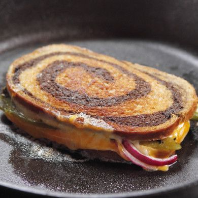 a grilled sandwich on a pan with onions and cheese in the middle, ready to be eaten