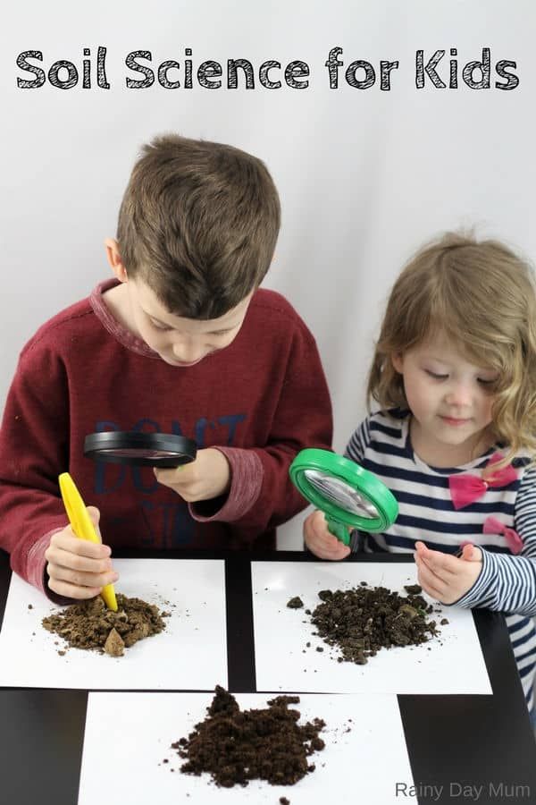 two children are playing with soil and magnifying glass in front of white background