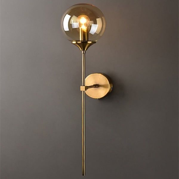 a wall light that is on the side of a wall with a glass ball hanging from it