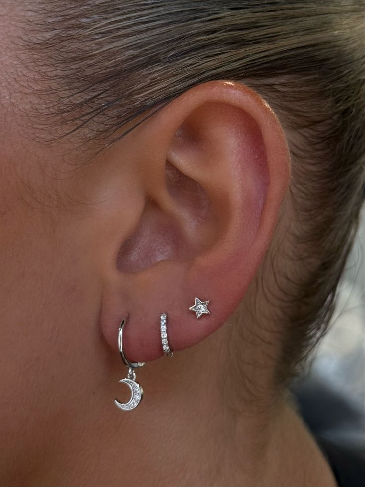 a close up of a person's ear with two stars and a moon on it