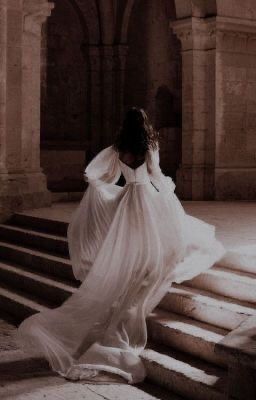 a woman in a white dress walking up some steps