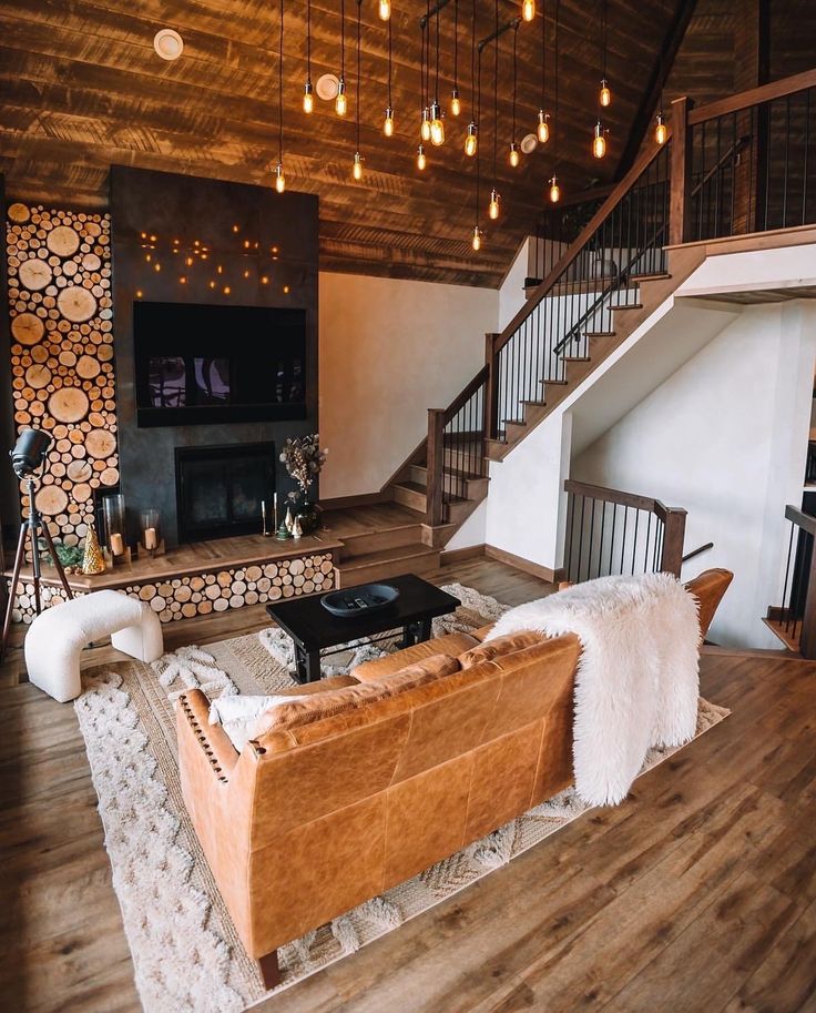 a living room filled with furniture and a fire place in the middle of a wooden floor