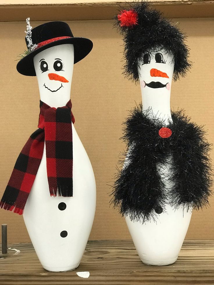 two snowmen wearing hats and scarves are sitting next to each other on a shelf