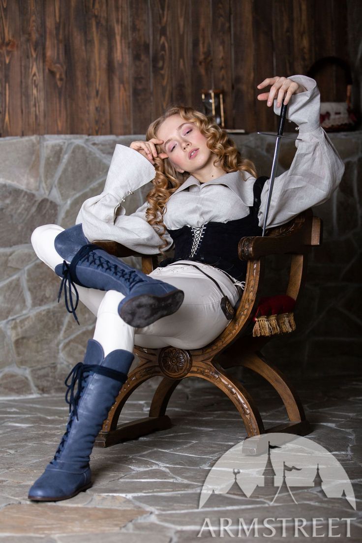 a woman sitting on top of a wooden chair with an umbrella in her hand and holding a cane