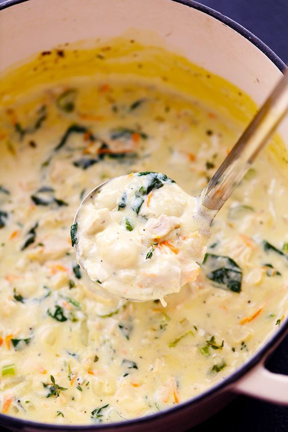 a ladle full of cheese and spinach soup