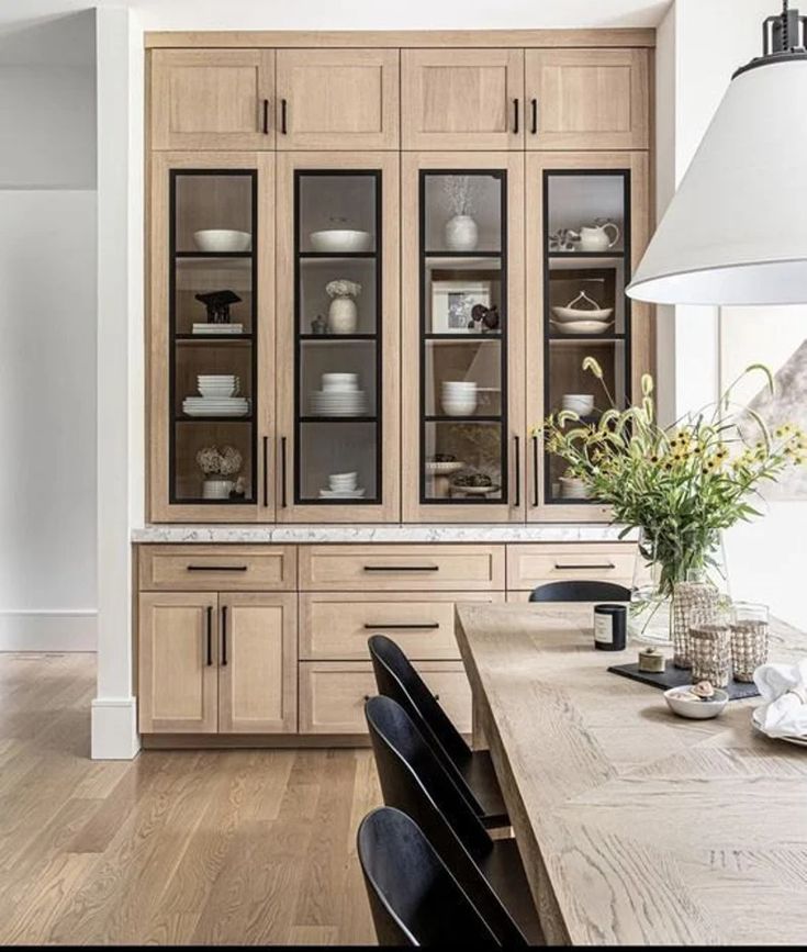 a kitchen with wooden cabinets and black chairs