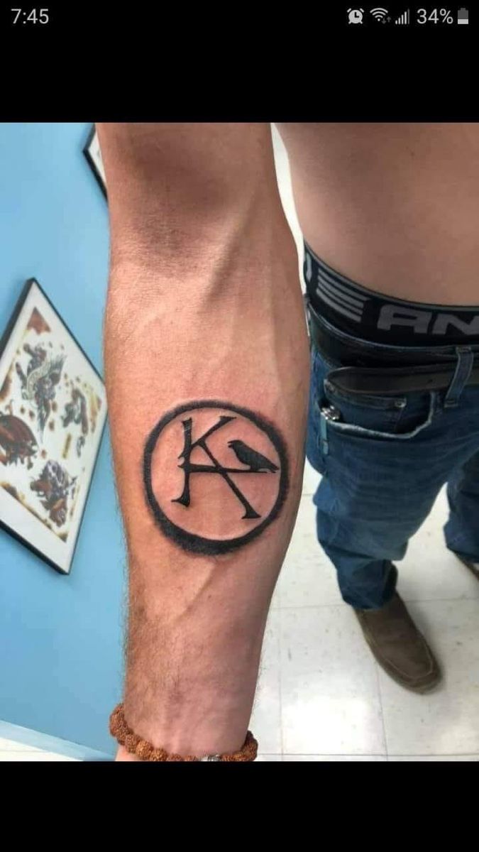 a man with a tattoo on his arm and leg that has the letter k in it