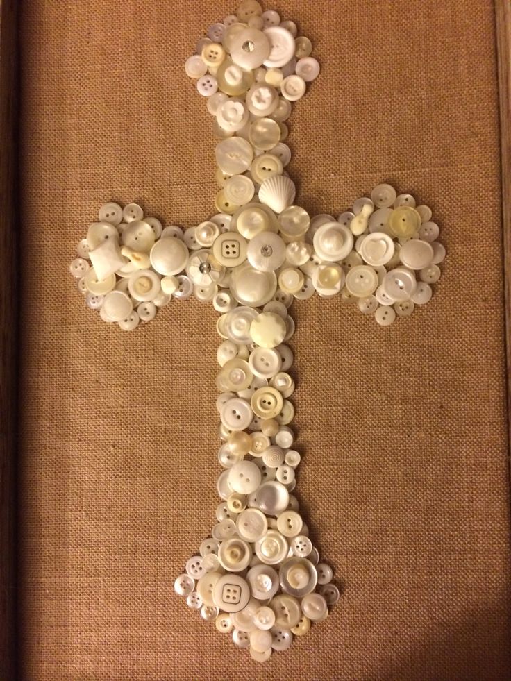 a cross made out of buttons in a frame