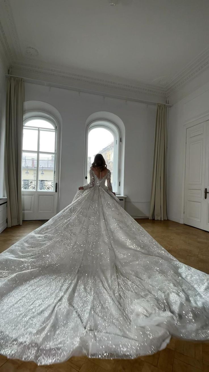 a woman in a wedding dress is standing on the floor with her back to the camera