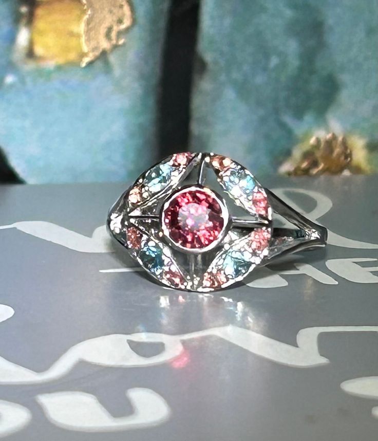 Genuine Multi Gemstones Mini Cocktail Ring Metal Type: Sterling Silver 925 White Gold Plated Size : 5.25 Main Stone: Pink Garnet  Color: Pink Cut: Facet Round Cut Blue Zircon Dimension Approximate: 3 mm Round Cut Pink Sapphire Dimension Approximate: 2 mm Ready to ship in 1-3 business days. ---- For more questions, please don't hesitate to contact me ---- You can also send me a message straight from Etsy  Thank you for taking the time to browse our galleries and we hope you will be able to visit Pink Sterling Silver Crystal Ring With Gem, Pink Sterling Silver Crystal Ring With Center Stone, Fusion Multi-stone Pink Jewelry, Silver Topaz Ring With Accent Stones, Pink Topaz Center Stone Ring In Sterling Silver, Dazzling Sterling Silver Gemstones, Silver Crystal Ring With Accent Stones For Jewelry Making, Pink Sterling Silver Ring With Stone Setting, Multicolor Round Jewelry With Halo Setting