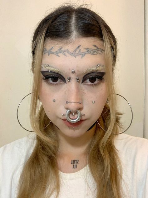 a woman with piercings on her nose and nose ring in front of her face