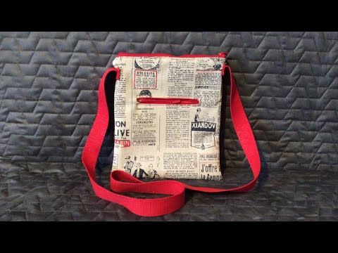 a newspaper bag sitting on top of a black bed covered in red string and fabric