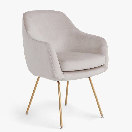 an upholstered grey chair with gold legs