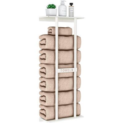 towels are stacked on top of a shelf