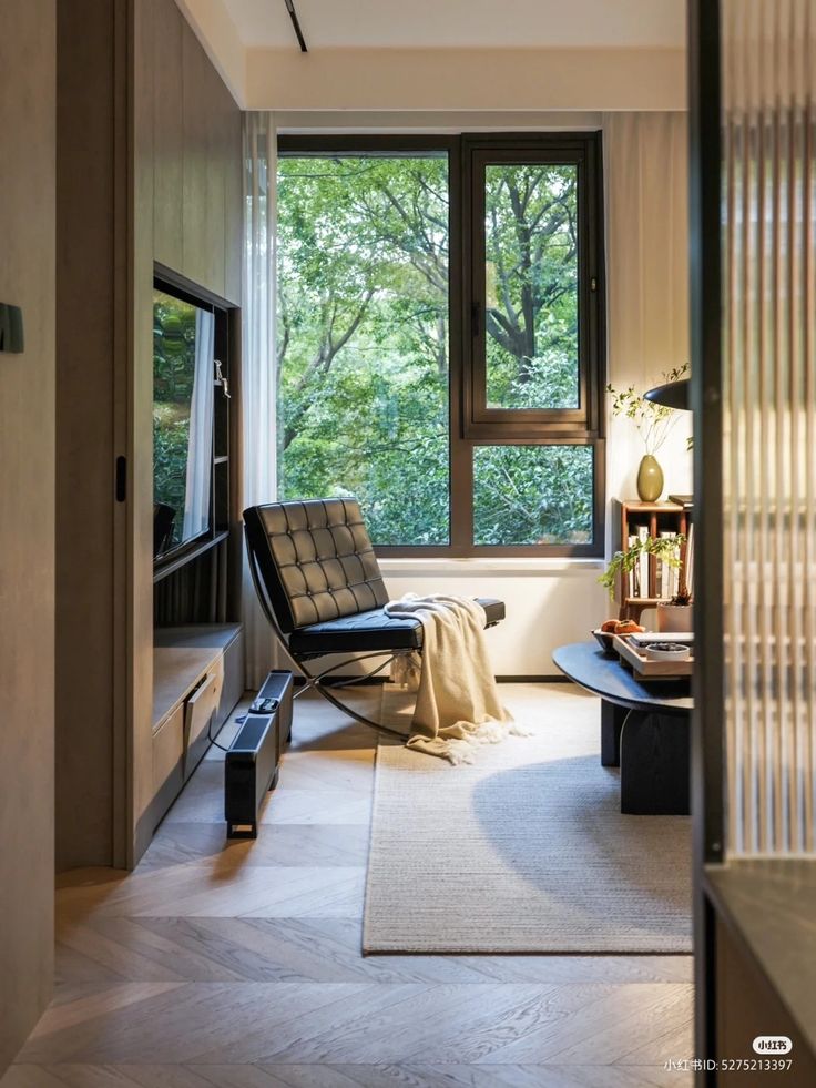 a living room filled with furniture and a large window next to a wall mounted tv