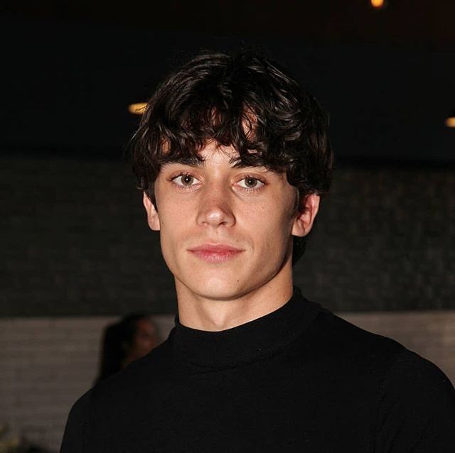 a young man in a black shirt posing for the camera