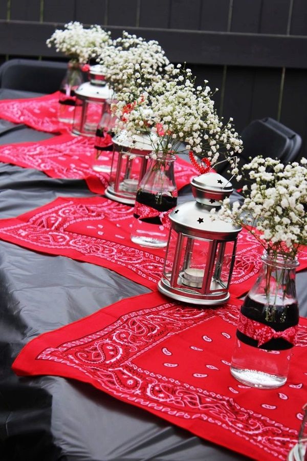 there are many vases with flowers in them sitting on the table cloth that is laid out