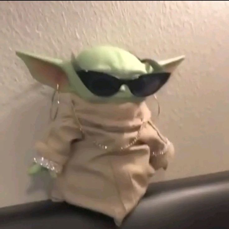 the baby yoda doll is wearing sunglasses