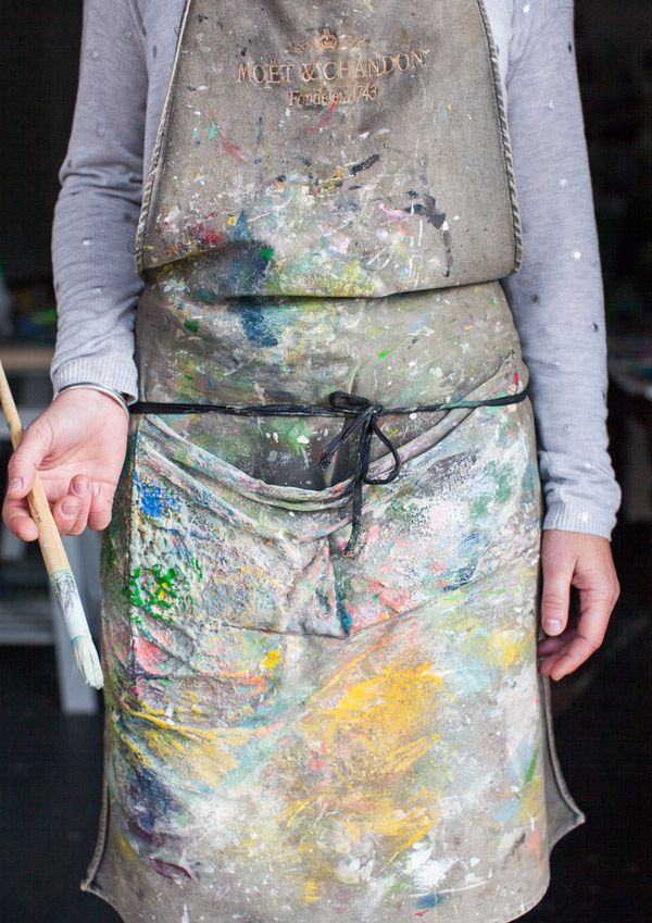 a person wearing an apron and holding a paintbrush