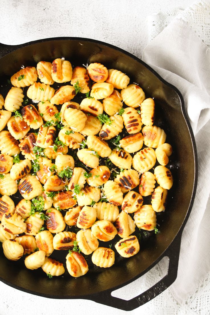 fried gnocchini with broccoli and parsley in a cast iron skillet