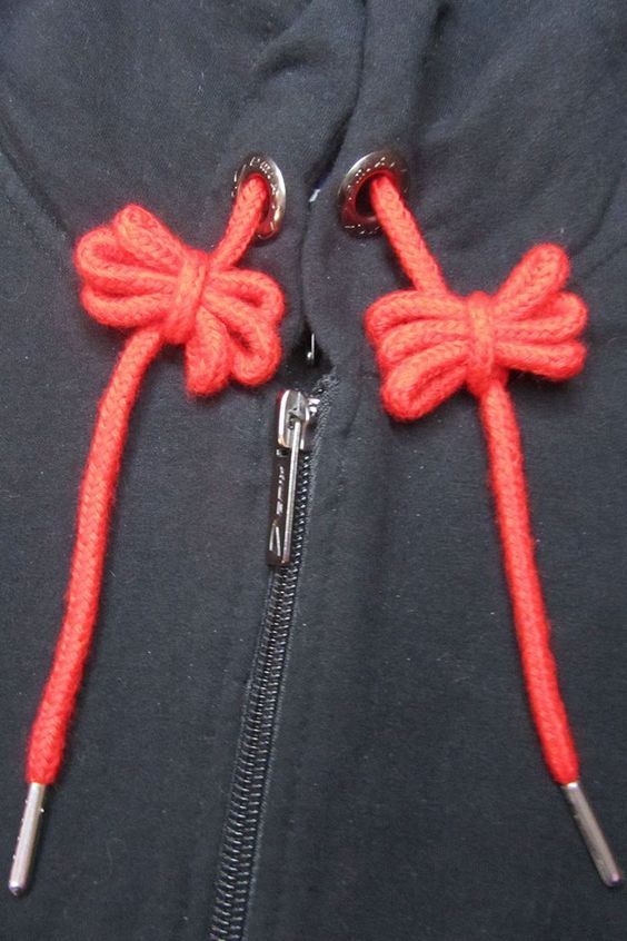 the zippers on this jacket are made out of red thread and metal hooks,