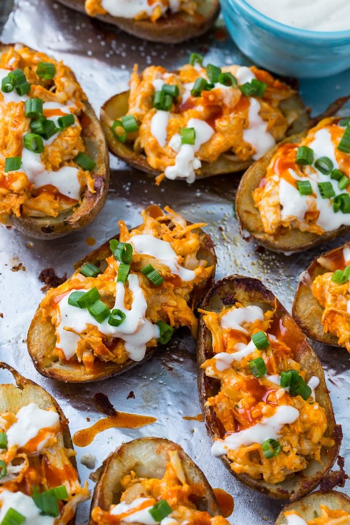 baked potato skins with cheese and green onions on a baking sheet, ready to be eaten