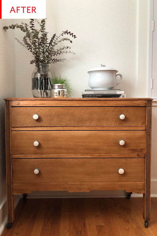 a wooden dresser with white knobs on it and a potted plant sitting on top