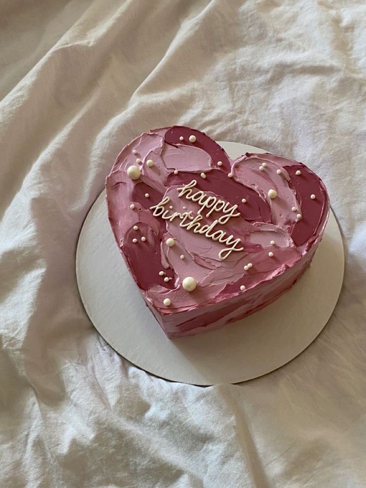 a heart shaped birthday cake on a white plate