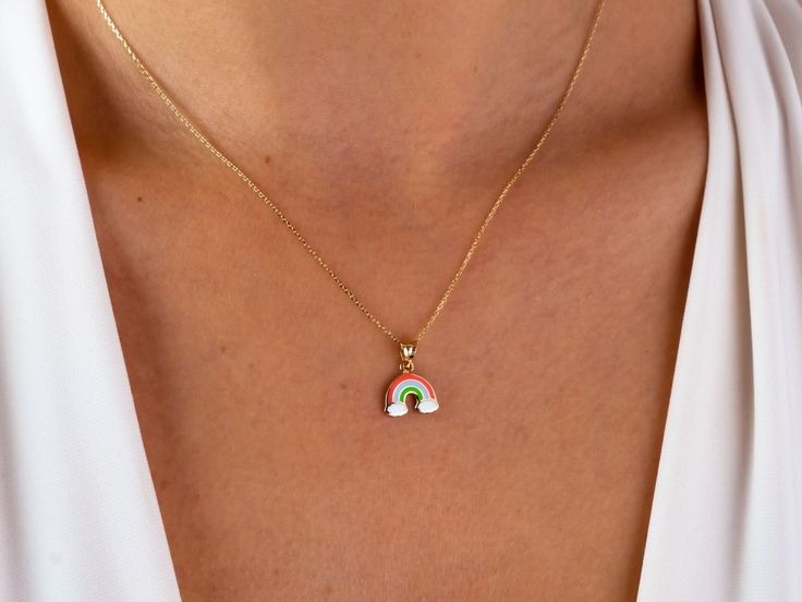 This 14K gold rainbow necklace is a colorful and dainty piece of jewelry that would make a beautiful gift for any occasion. The rainbow pendant is a symbol of friendship and pride, and would be a thoughtful present for a loved one on Christmas, Father's Day, Mother's Day, Valentine's Day, an anniversary, or a birthday. The necklace is a choker style and would sit close to the neck, making it perfect for layering with other necklaces or wearing on its own. It would make a lovely addition to any j Rainbow Necklace With Adjustable Chain For Gift, Personalized Rainbow Necklaces For Gifts, Rainbow Pendant Jewelry Gift, Handmade Rainbow Necklaces For Everyday Wear, Colorful Pendant Jewelry As A Gift, Handmade Rainbow Necklaces For Everyday, Handmade Rainbow Necklace For Everyday, Dainty Multicolor Charm Necklace For Gift, Dainty Multicolor Charm Necklace As Gift