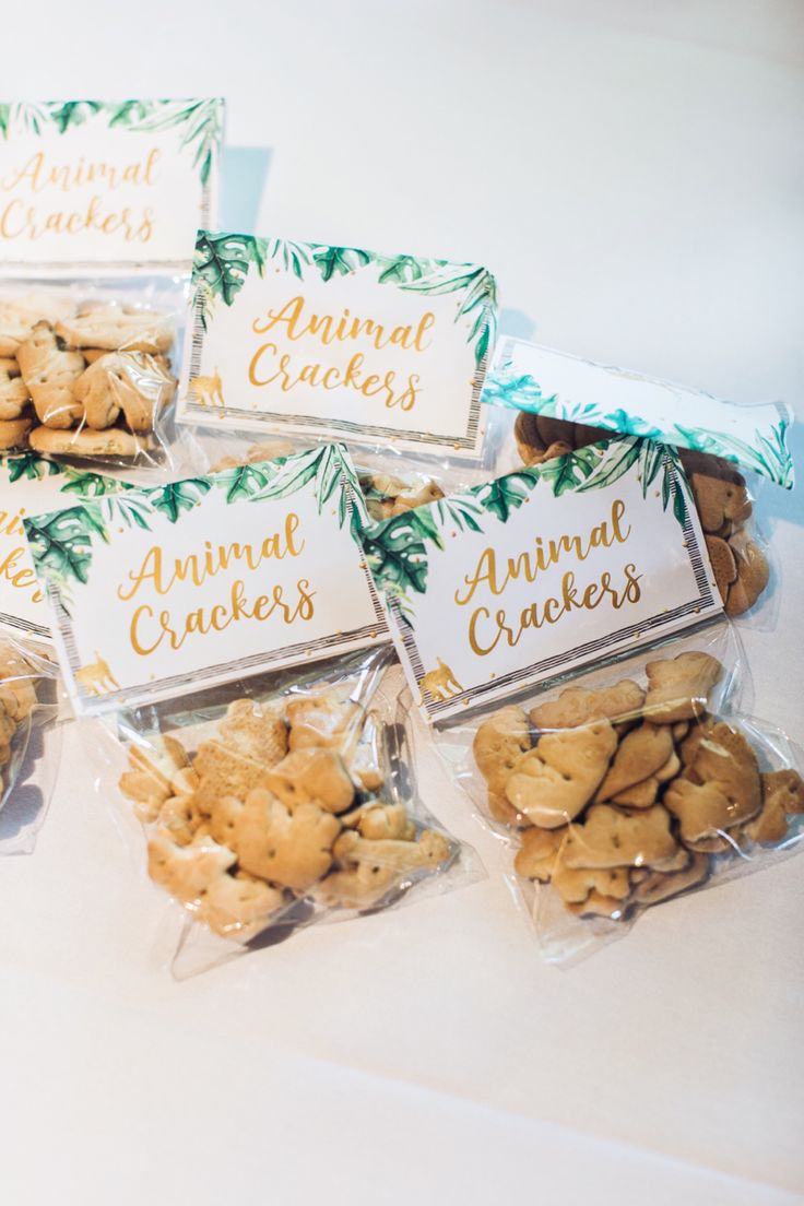 there are many small bags of cookies on the table with name tags attached to them