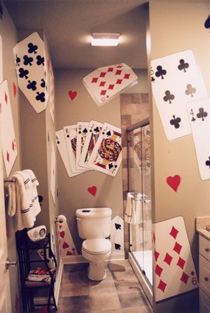 a bathroom with playing cards on the wall