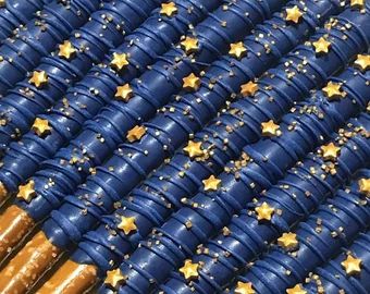 some blue and gold stars are on top of each other in the air with brown sticks sticking out of them