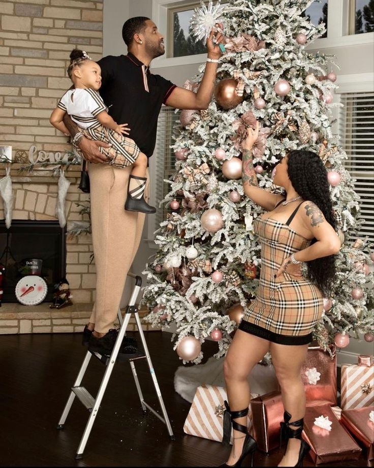 a man and woman standing next to a christmas tree