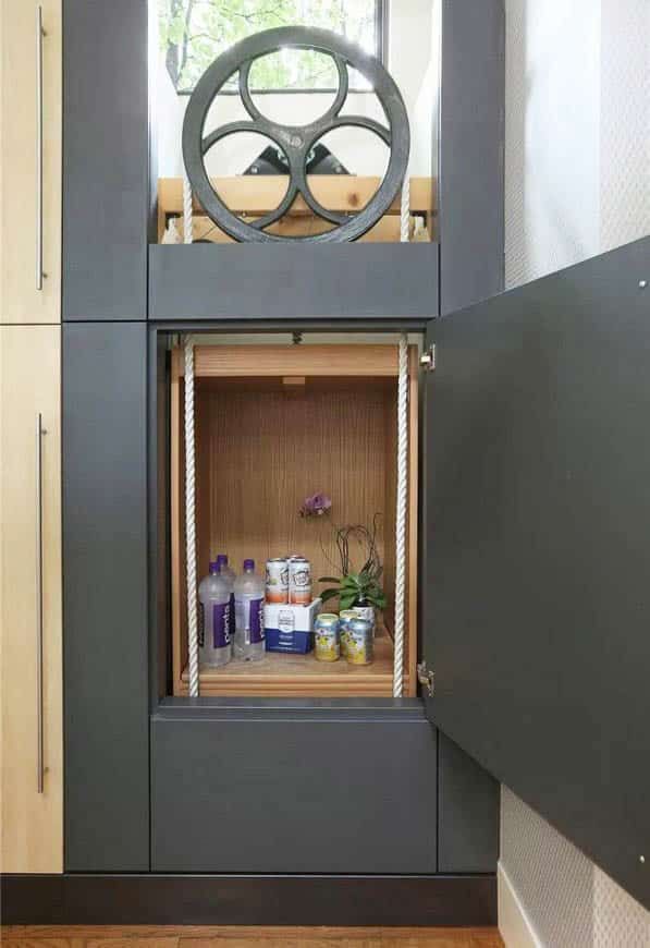 an open cabinet in the corner of a room with various items on it and a steering wheel