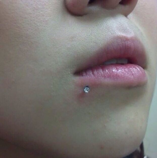 a close up of a person's nose with a diamond ring on their lip