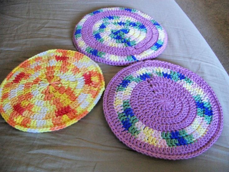 three crocheted plates sitting on top of a bed