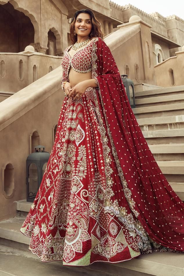 Scarlet red flared cancan lehenga with mughal bloom garden embroidery using cut dana, pearls, tikki, sequin highlights. Paired with long sleeves cut work detail sweetheart neckline padded blouse with dangling teardrop moti, sequins, cut dana jaal, tonal beads embellishments and white lace border dupatta with red sequin flora embroidered dupatta.
Components: 4
Pattern: Embroidery
Type Of Work: Cutdana, Pearls, Tikki, Sequins
Neckline: Sweetheart Neck
Sleeve Type: Long
Fabric: Silk, Organza
Color: Red Anarkali Sharara For Reception, Red Gown For Reception And Navratri, Red Gown For Navratri Reception, Red Gown For Reception At Navratri, Red Lehenga With Dupatta For Reception, Red Semi-stitched Sharara For Reception, Red Cutdana Gown For Eid, Red Anarkali Lehenga With Sheer Dupatta, Red Anarkali Lehenga For Reception