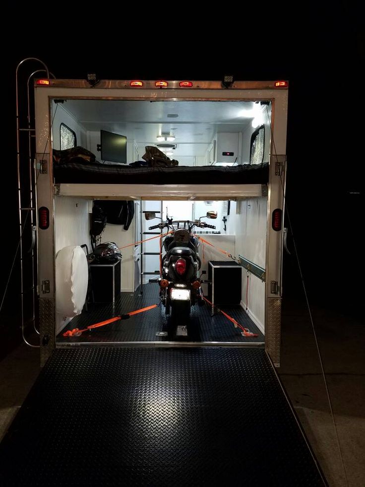 a motorcycle is parked in the back of a truck with it's lights on