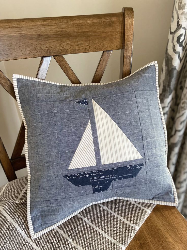 a blue pillow with a sailboat on it